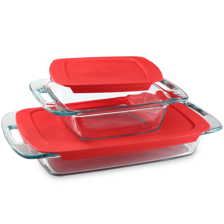 Set of glass baking dishes with red lids on a white background