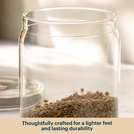 Clear glass jar with seeds inside on a neutral background