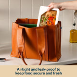 Glass food container with clear lid inside a tote bag.