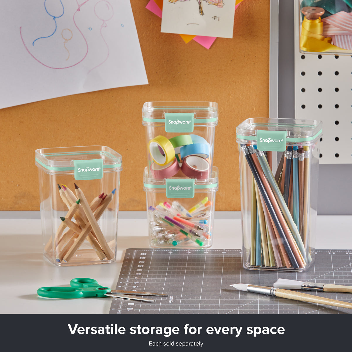 Snapware® clear plastic storage containers with mint green lids used to organize craft supplies, including colored pencils, markers, tape rolls, and pens on a workspace.