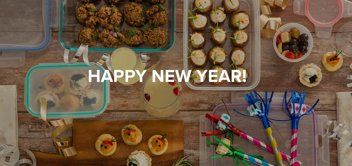 Assorted food items and party supplies on a wooden table with 'Happy New Year!' text overlay.
