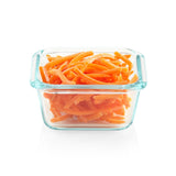 Glass container filled with orange shredded carrots on a white background