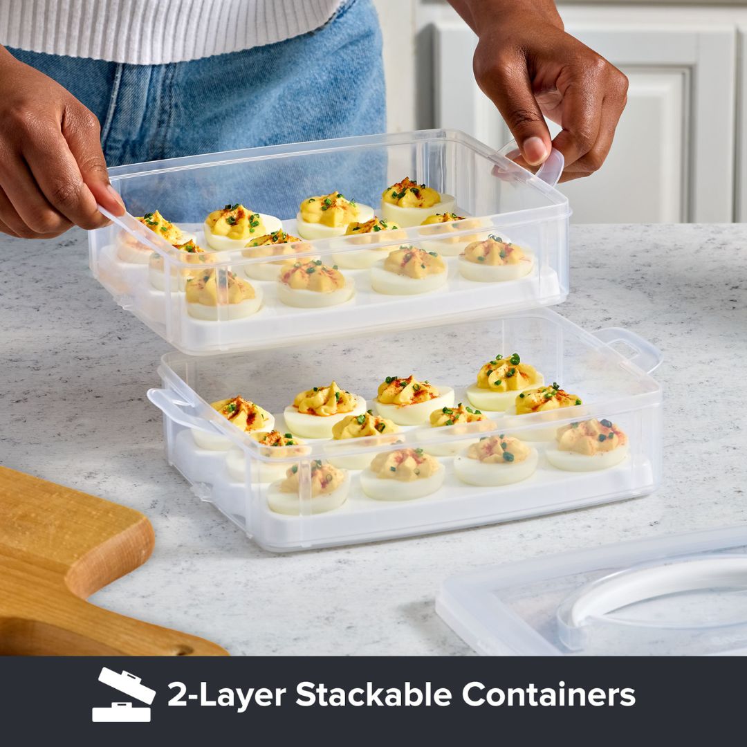 2-layer stackable containers with deviled eggs on a marble countertop