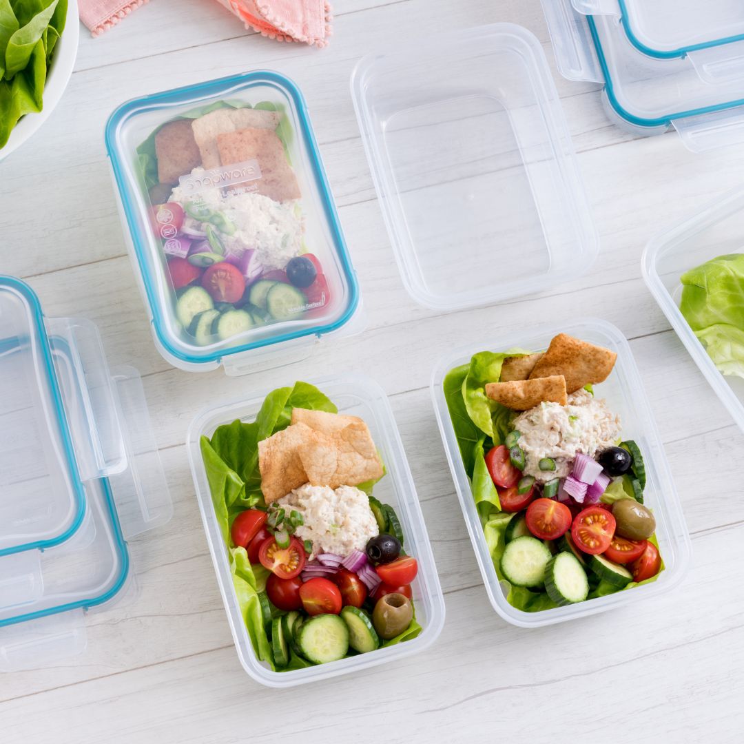 Prepared salads in containers on a white surface