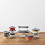 Set of glass containers with gray lids on a wooden surface