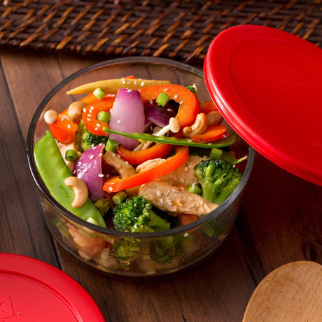 Glass container with a colorful salad on a wooden surface