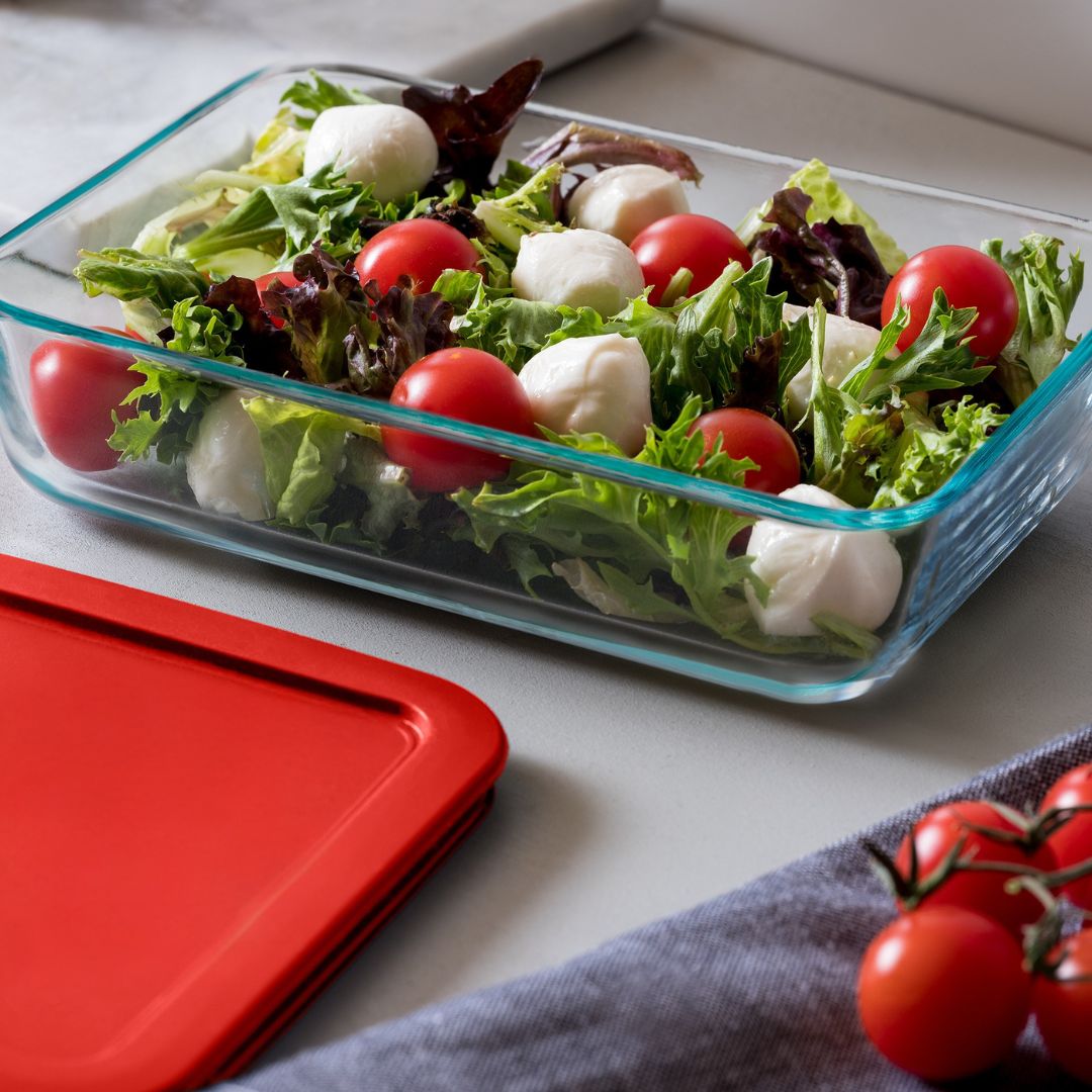 Glass container with salad on a white surface