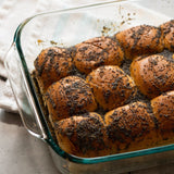 Baked rolls with poppy seeds in a glass dish on a countertop