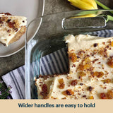 Glass baking dish with dessert, slice on plate, and text 'Wider handles are easy to hold'.