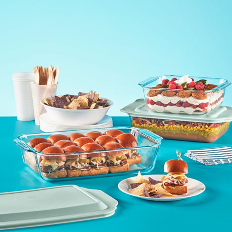 Glass food containers with sliders and a dessert on a blue background
