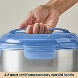 Hand holding a blue lid on a metal bowl with text about its capacity and feature.