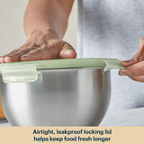 Person holding a green airtight lid over a metal bowl with text about keeping food fresh.