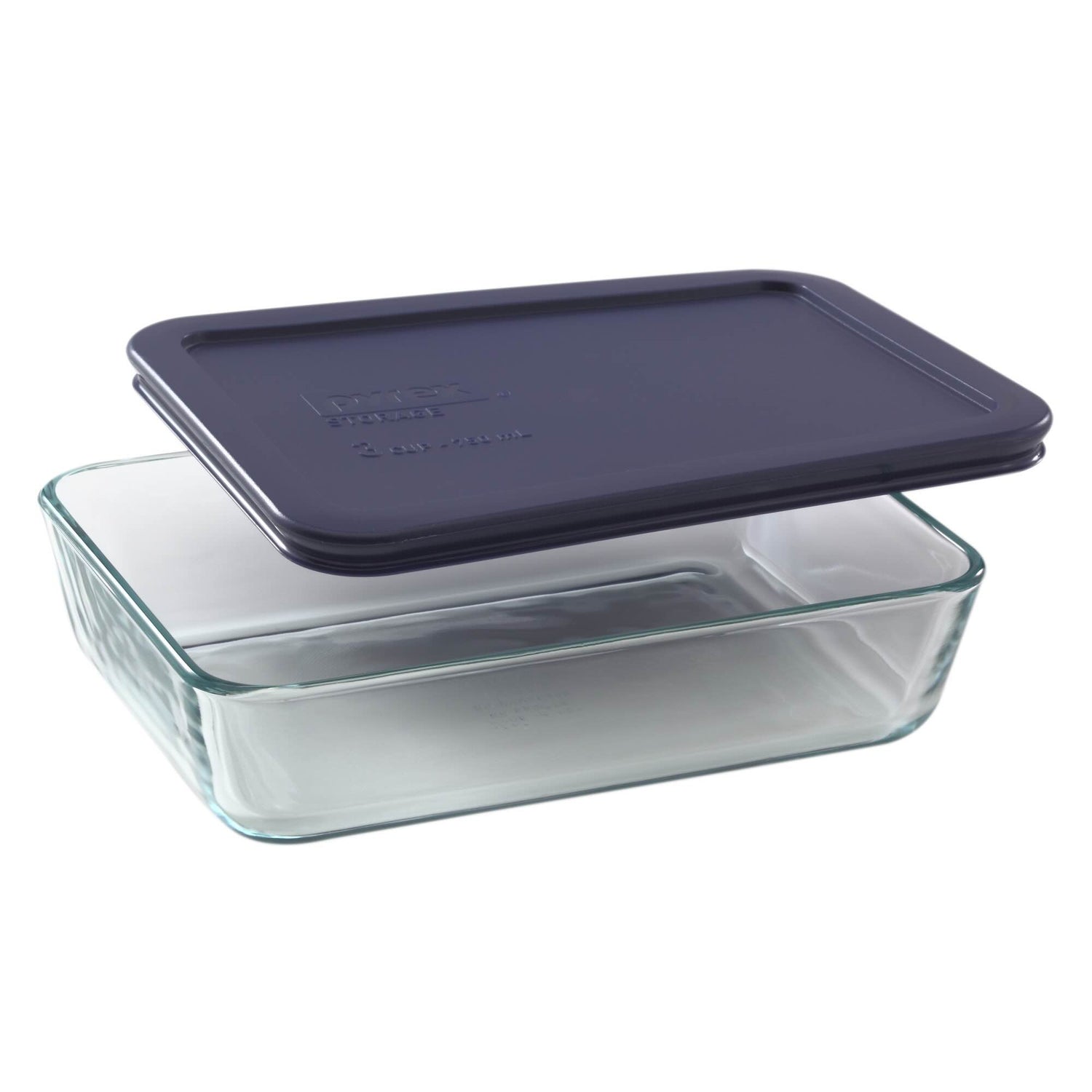 Glass food storage container with a navy blue lid on a white background